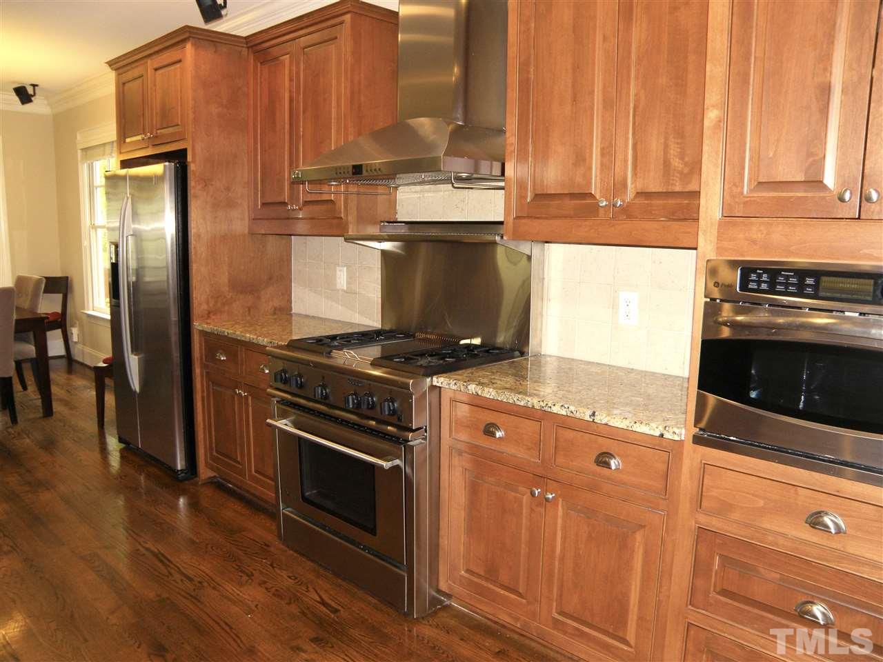 2702 Bedford Avenue Raleigh, NC 27607 - Photo 7 of 25 a kitchen with stainless steel appliances granite countertop a stove and a refrigerator