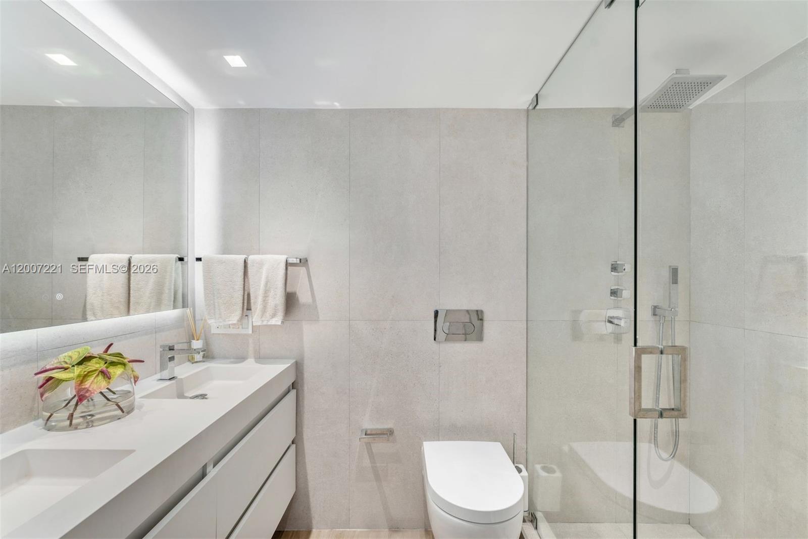 2301 Collins Avenue, Unit 902 Miami Beach, FL 33139 - Photo 16 of 22 a bathroom with a sink a toilet and shower
