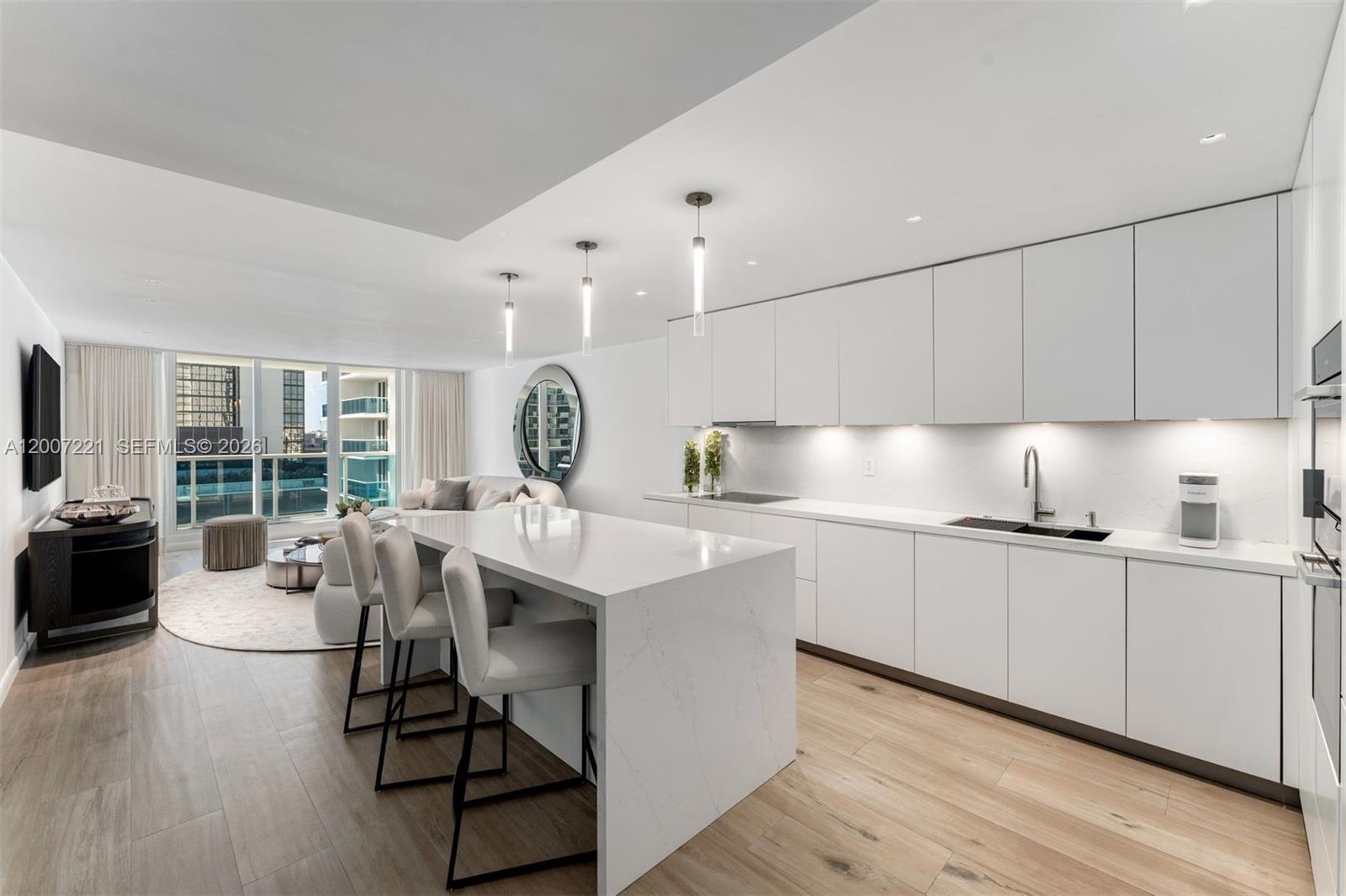 2301 Collins Avenue, Unit 902 Miami Beach, FL 33139 - Photo 6 of 22 a kitchen with counter top space a sink cabinets and stainless steel appliances