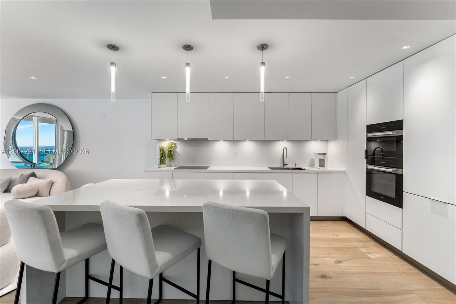 2301 Collins Avenue, Unit 902 Miami Beach, FL 33139 - Photo 7 of 22 a kitchen with a table chairs refrigerator and microwave