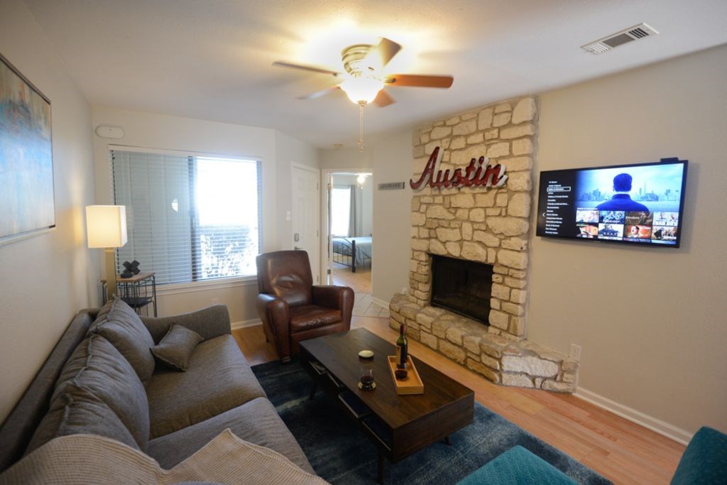 1720 Timber Ridge Road, Unit 167 Austin, TX 78741 - Photo 1 of 1 a living room with furniture a flat screen tv and a fireplace