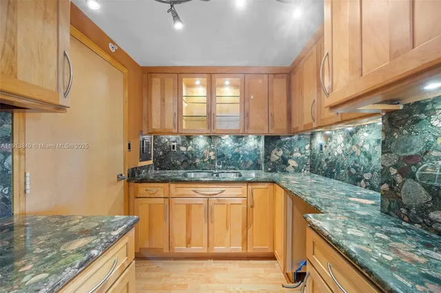 a kitchen with granite countertop sink and cabinets