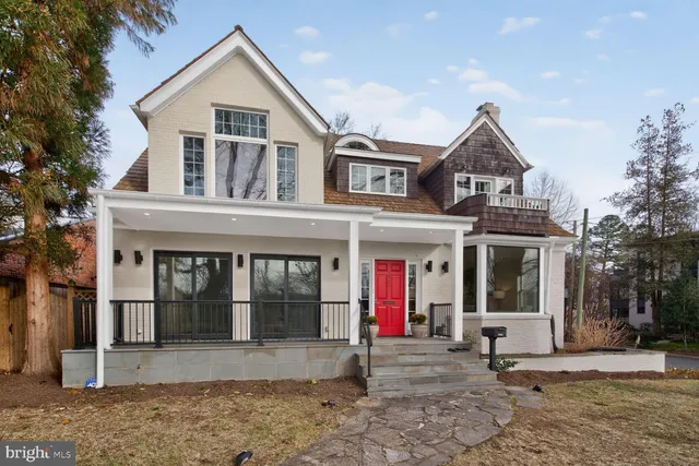 a view of a white house with large windows and a small yard