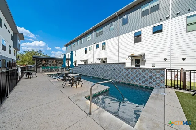a view of backyard with swimming pool and furniture