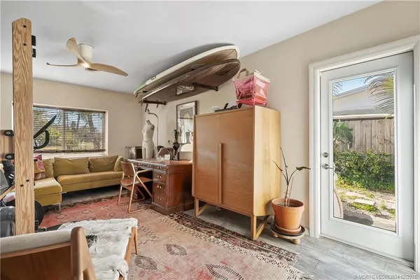 a front view of a house with a large window and potted plants