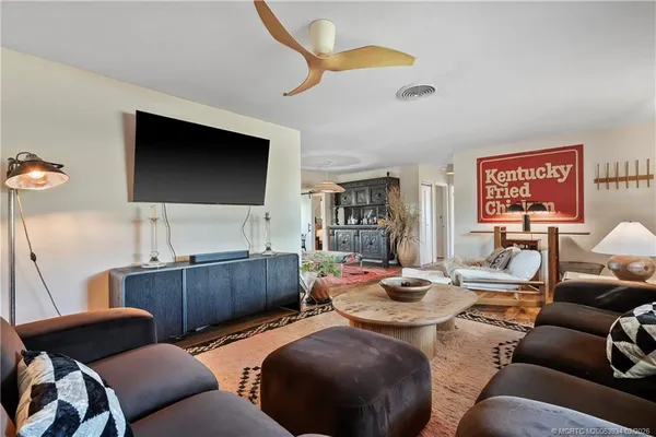 a kitchen with stainless steel appliances granite countertop a refrigerator a stove a sink dishwasher and white cabinets with wooden floor