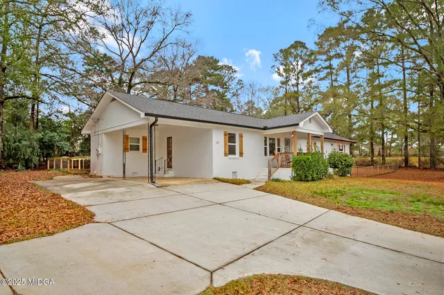 a view of a house with a yard and large tree