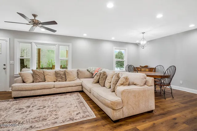 a kitchen with stainless steel appliances granite countertop a stove a sink dishwasher and a refrigerator with wooden floor