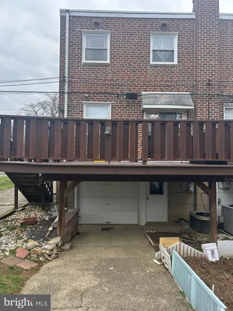 a view of house with wooden deck and furniture