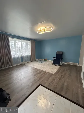 a view of a livingroom with an empty space and a window