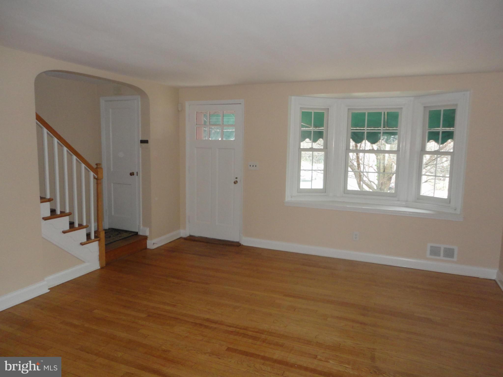 224 Stanmore Road Baltimore, MD 21212 - Photo 2 of 19 a view of an empty room with wooden floor and a window