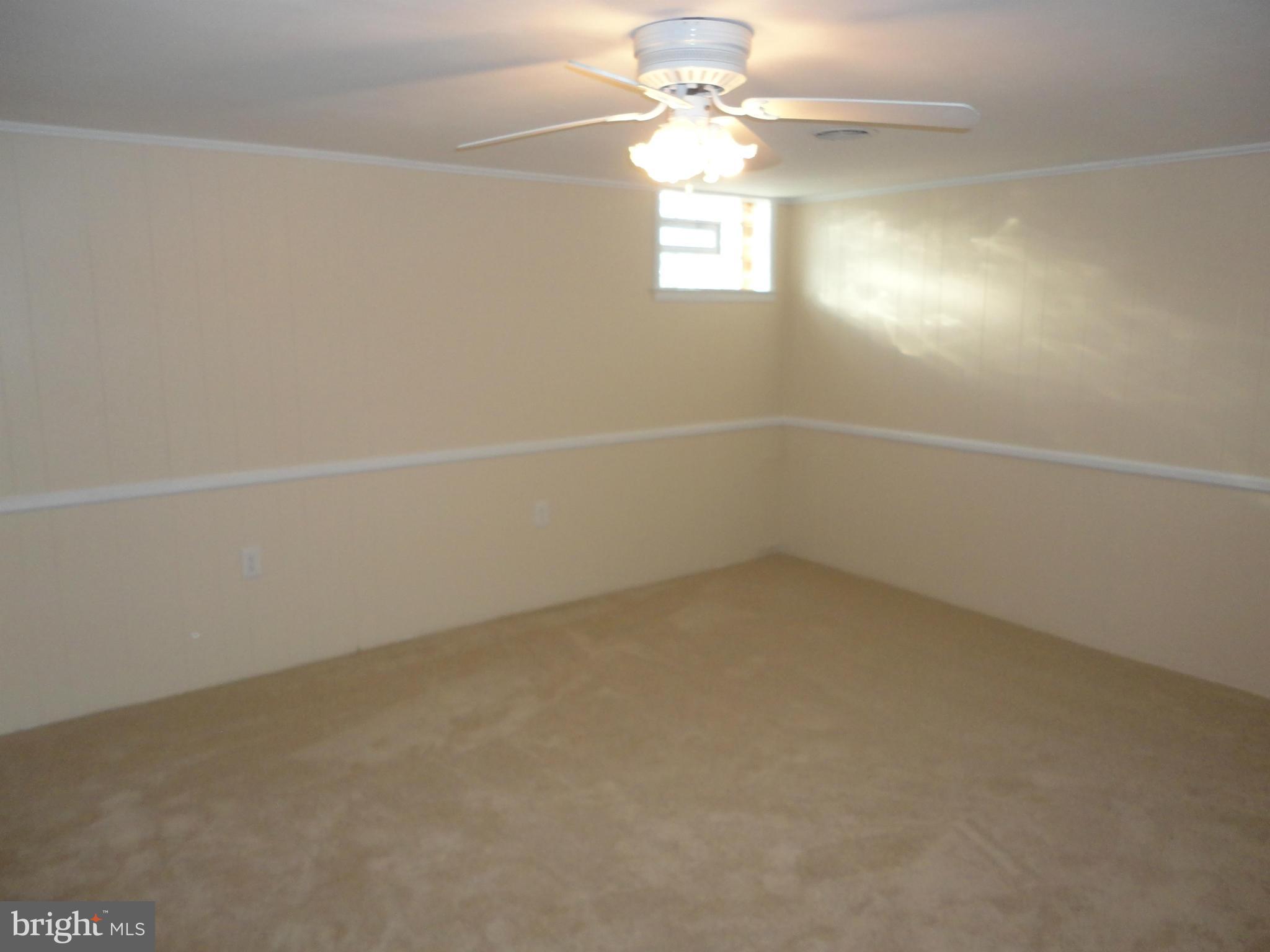 224 Stanmore Road Baltimore, MD 21212 - Photo 14 of 19 an empty room with a window and a fan