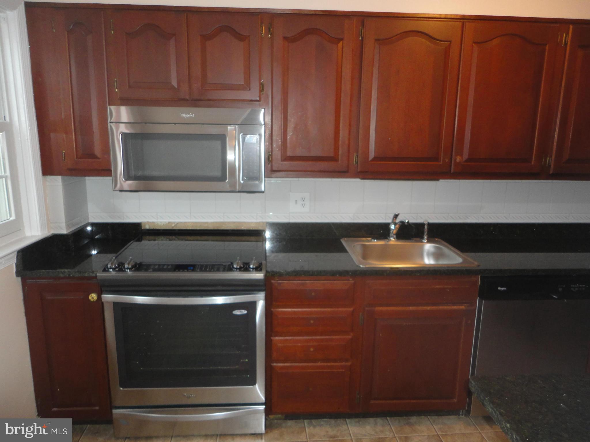 224 Stanmore Road Baltimore, MD 21212 - Photo 3 of 19 a kitchen with granite countertop wood cabinets and stainless steel appliances