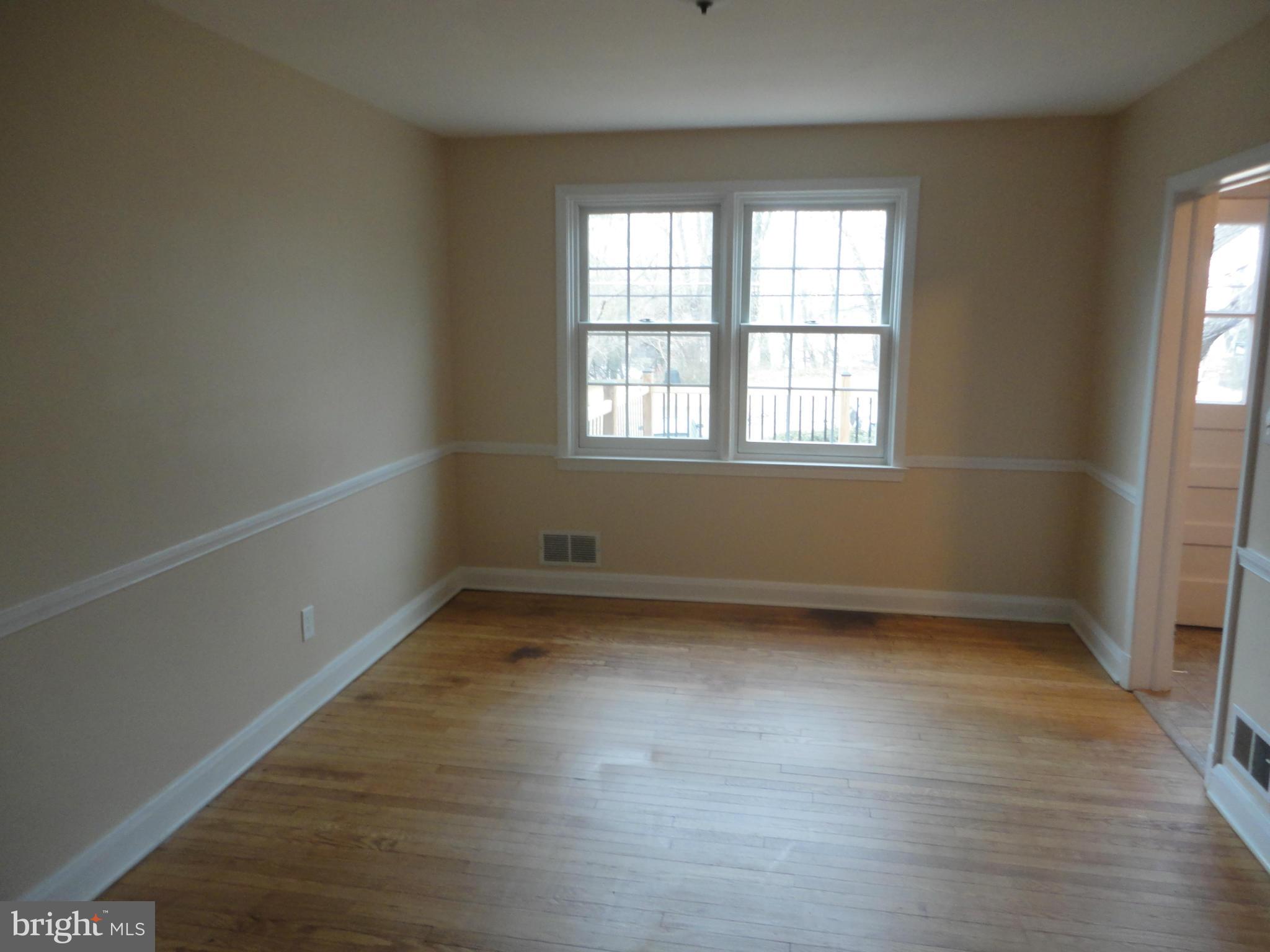 224 Stanmore Road Baltimore, MD 21212 - Photo 5 of 19 an empty room with wooden floor and windows