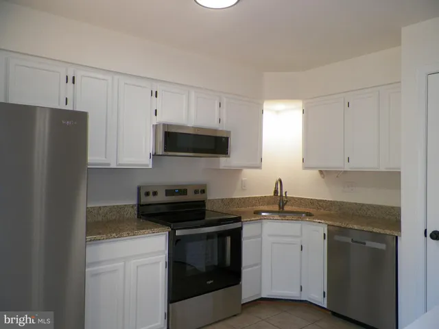 a view of kitchen with wooden floor and electronic appliances
