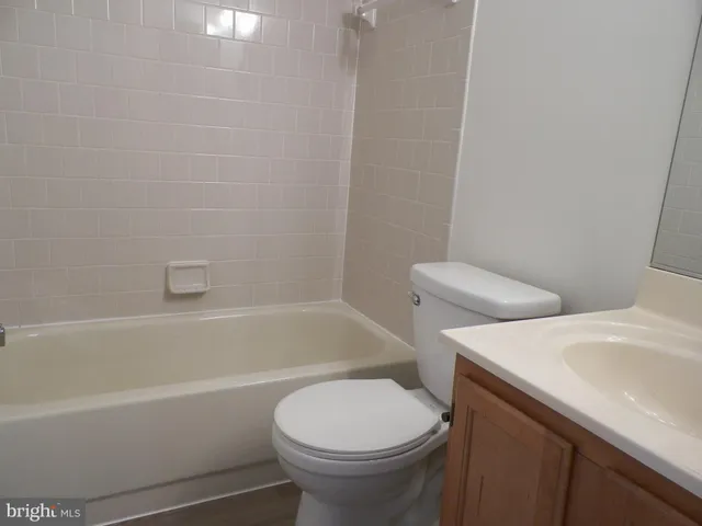 a white toilet sitting next to a bath tub