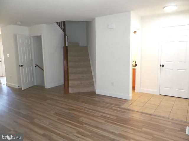 a view of an empty room with wooden floor and entryway
