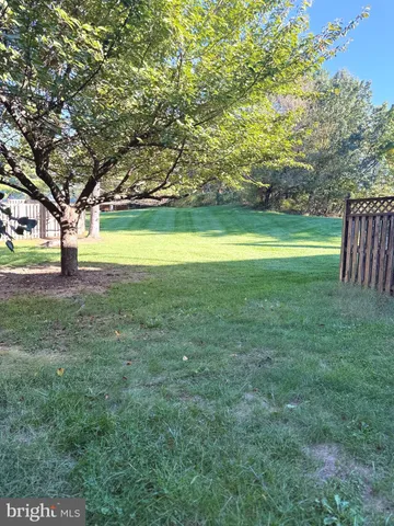 a view of a house with a big yard and large trees