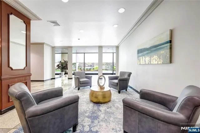 a living room with furniture a rug potted plant and a large window