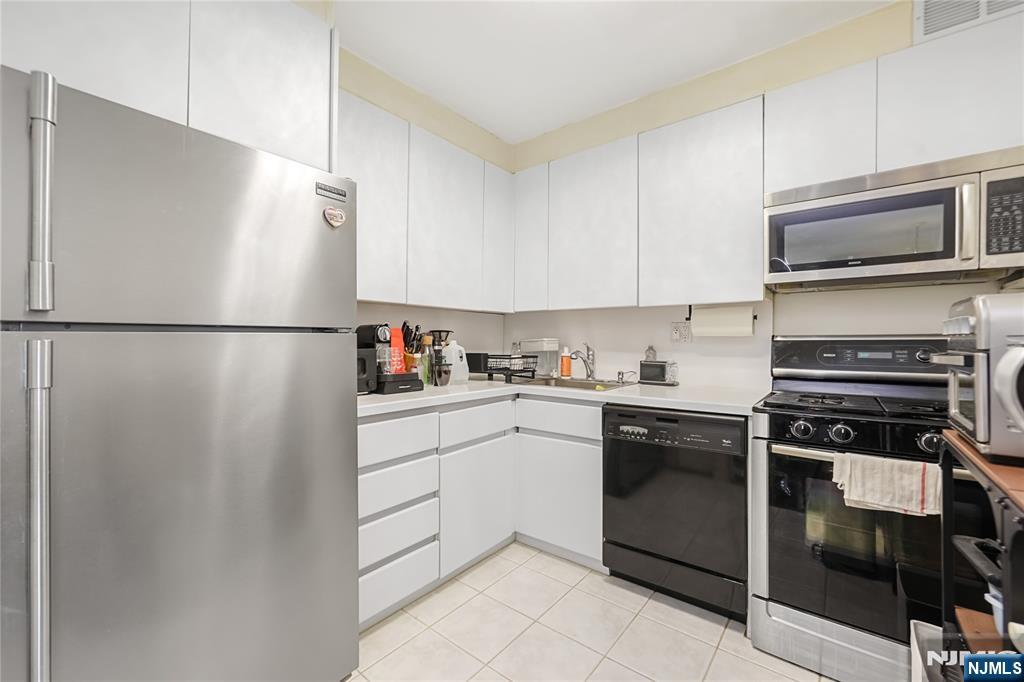 2000 Linwood Avenue, Unit 5L Fort Lee, NJ 07024 - Photo 7 of 26 a kitchen with a refrigerator stove and microwave