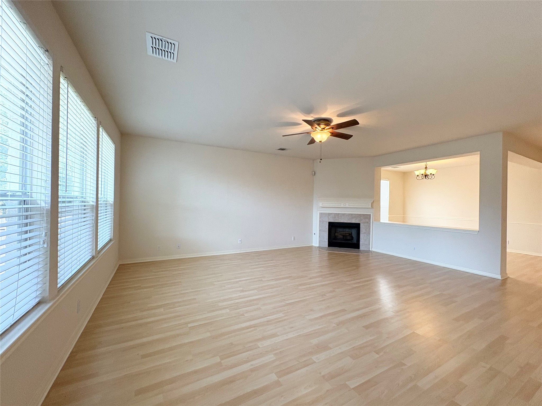 7006 Rambollet Terrace Round Rock, TX 78681 - Photo 10 of 38 A well-lit living area features light wood flooring and a classic fireplace, perfect for relaxation.