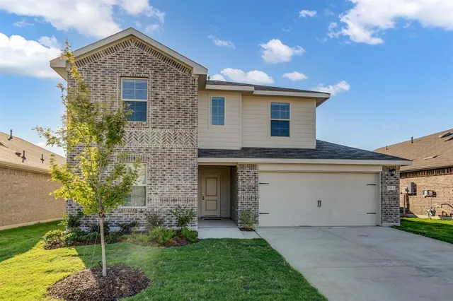 a front view of a house with a garden and plants