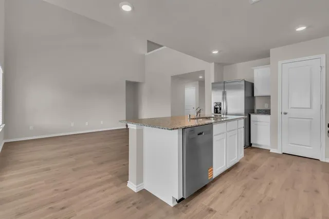 a kitchen with white cabinets and refrigerator