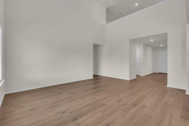 a view of an empty room with wooden floor and closet