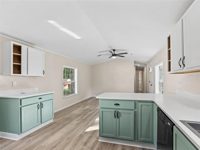 a kitchen with a sink cabinets and wooden floor