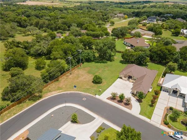 an aerial view of a house with a yard and lake view