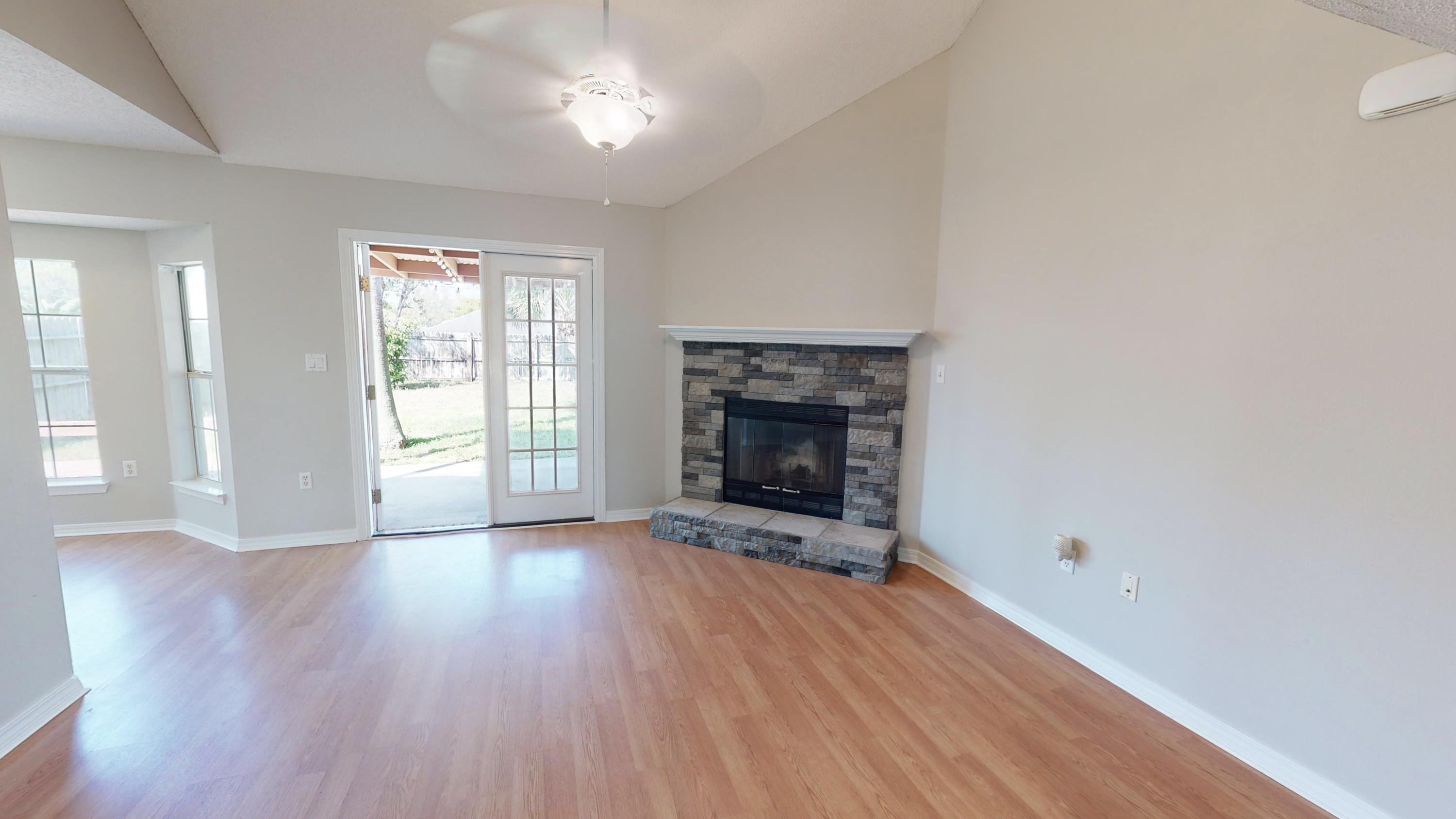 3621 Goldsbys Way Destin, FL 32541 - Photo 11 of 38 an empty room with wooden floor fireplace and windows