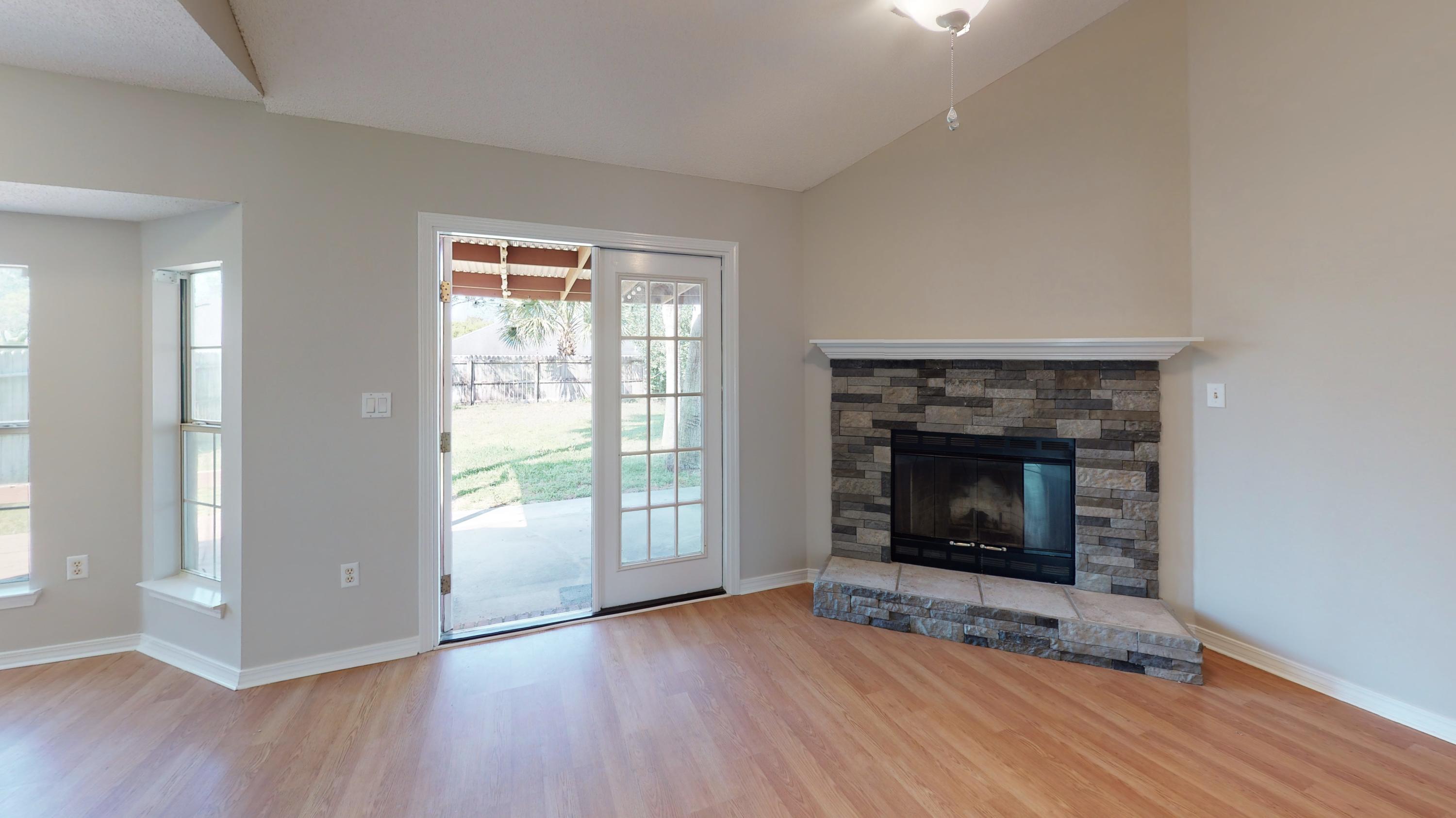 3621 Goldsbys Way Destin, FL 32541 - Photo 12 of 38 an empty room with wooden floor fireplace and windows