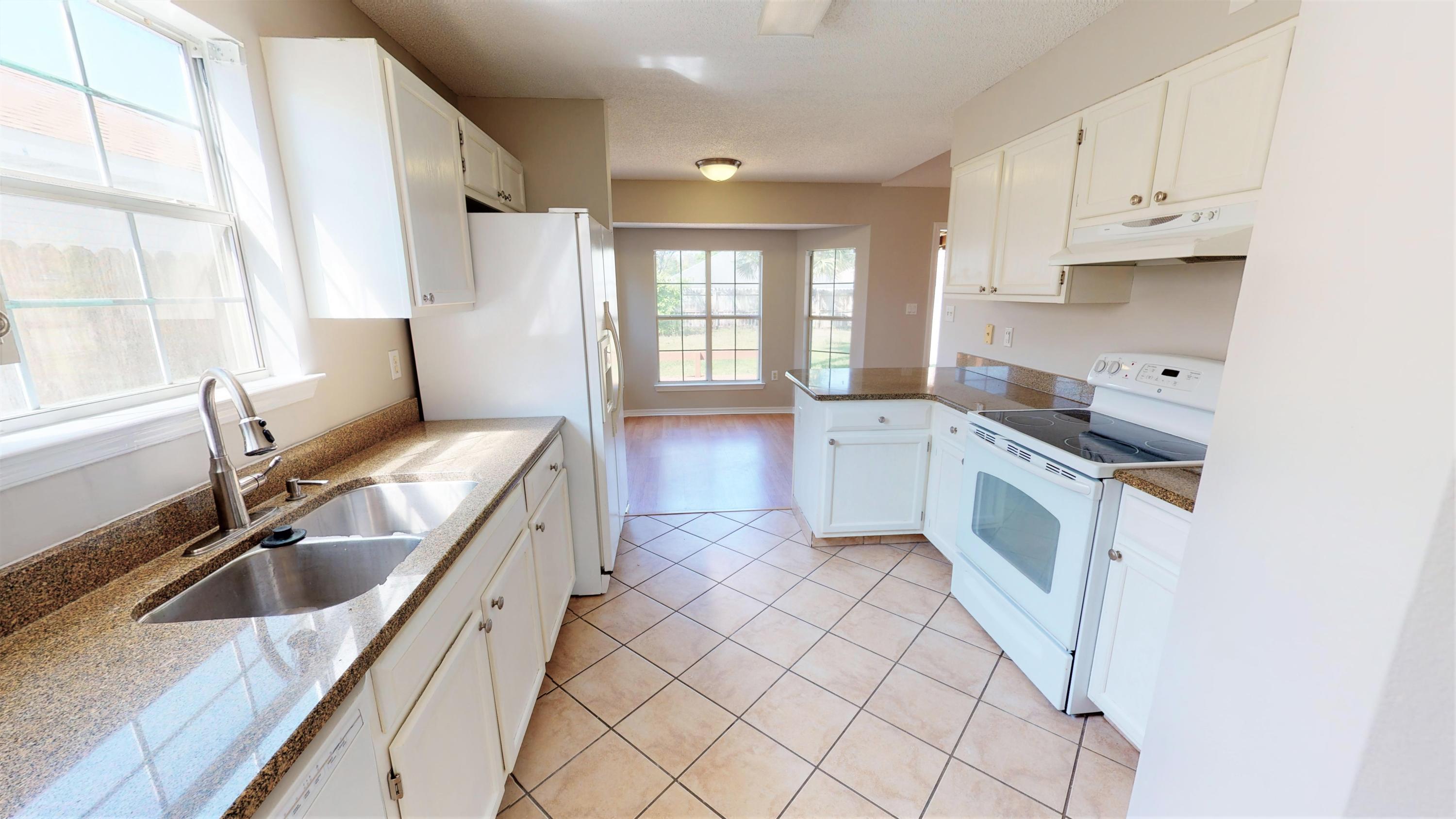 3621 Goldsbys Way Destin, FL 32541 - Photo 16 of 38 a kitchen with granite countertop a sink stove and cabinets