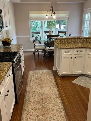 a kitchen with stainless steel appliances granite countertop white cabinets and granite counter tops