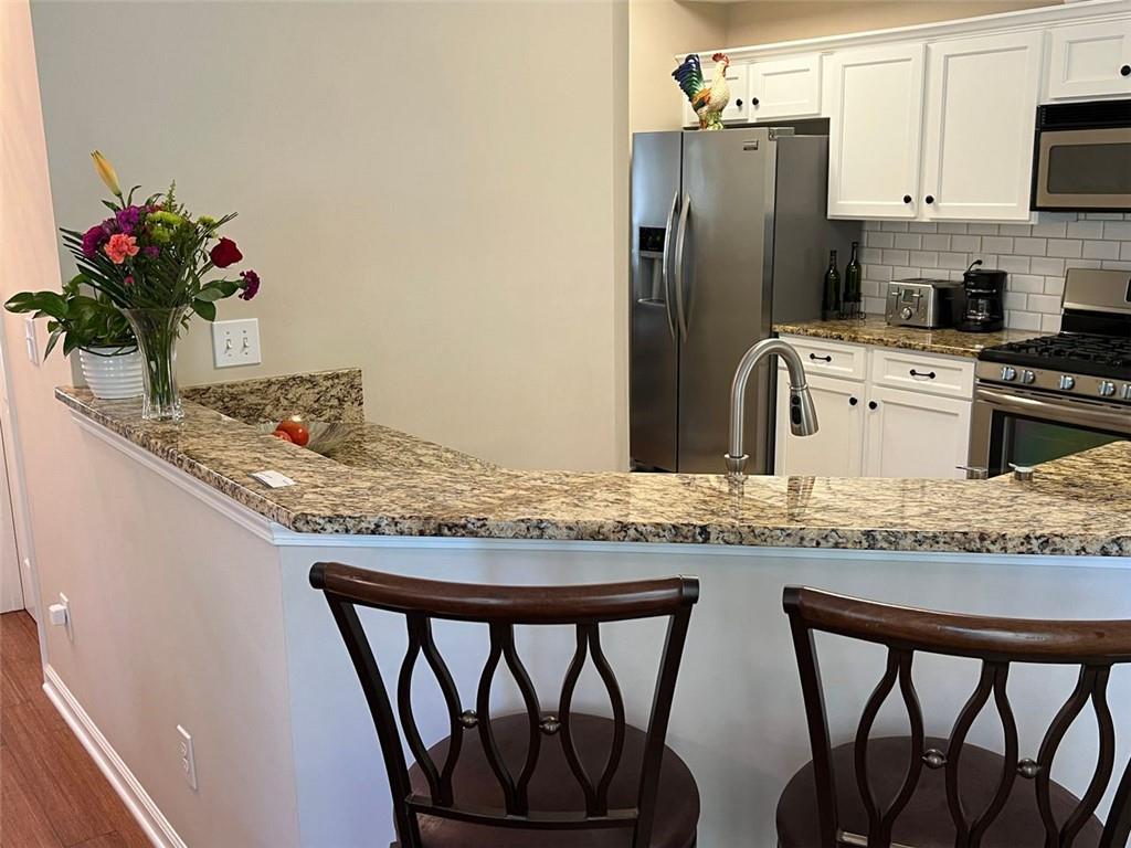 2430 Jakin Way Suwanee, GA 30024 - Photo 14 of 55 a kitchen with stainless steel appliances granite countertop white cabinets and granite counter tops