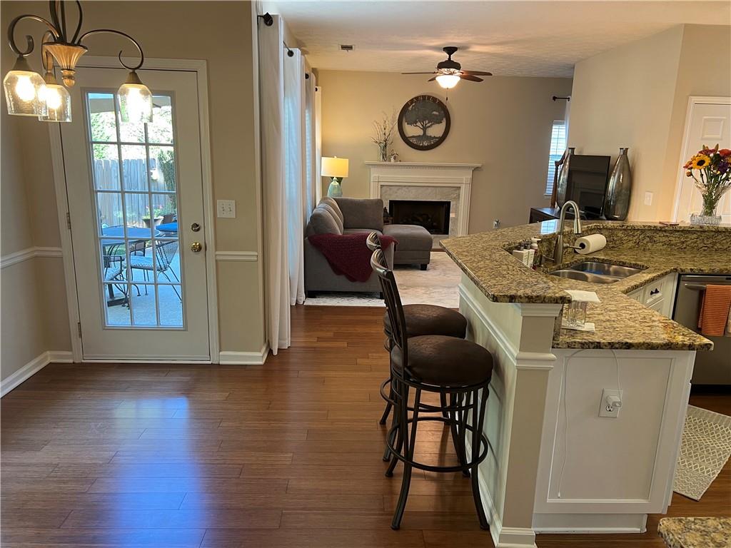 2430 Jakin Way Suwanee, GA 30024 - Photo 17 of 55 a living room with furniture a fireplace and a chandelier