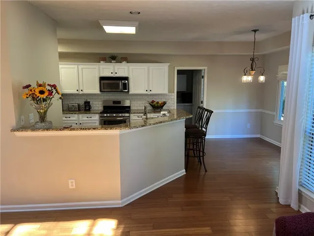 a kitchen with granite countertop white cabinets and white appliances