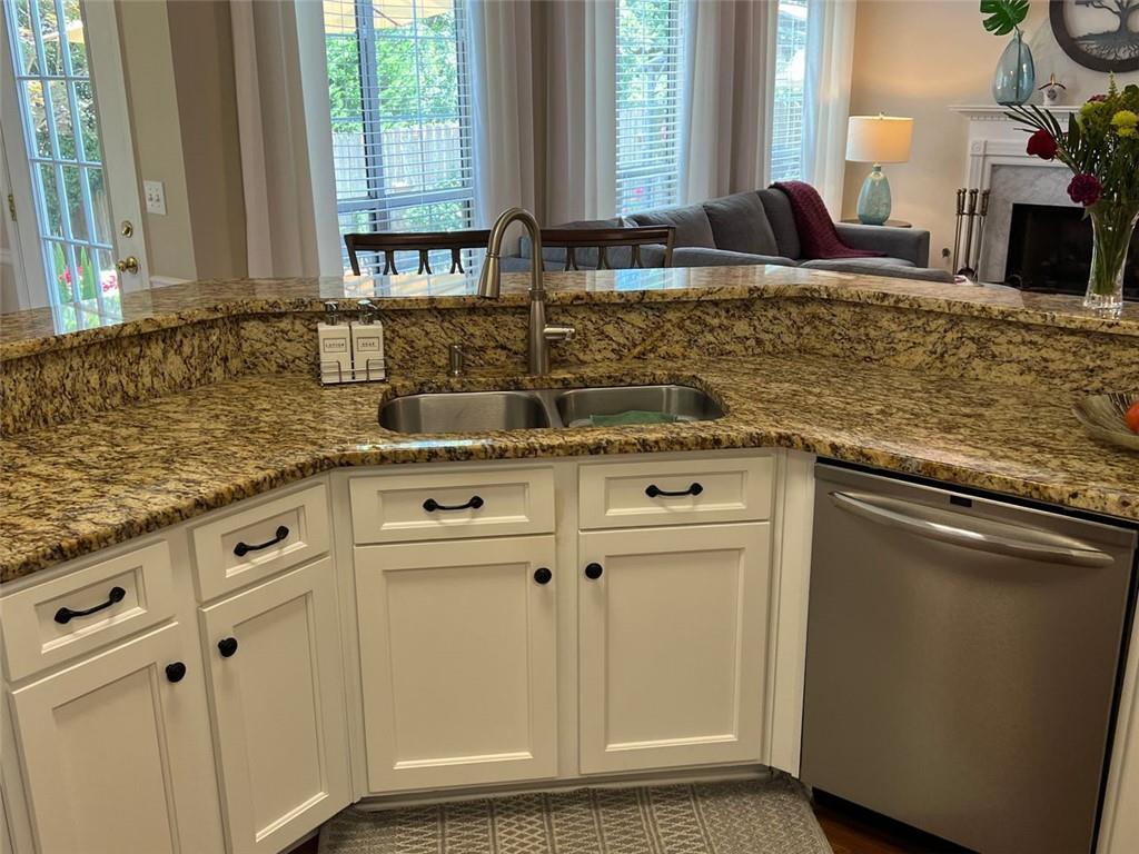 2430 Jakin Way Suwanee, GA 30024 - Photo 19 of 55 a kitchen with granite countertop white cabinets and white appliances