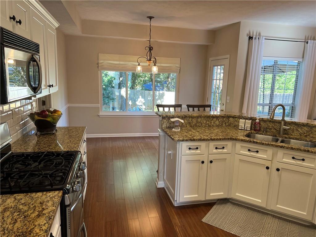 2430 Jakin Way Suwanee, GA 30024 - Photo 22 of 55 a kitchen with a sink stove and wooden floor