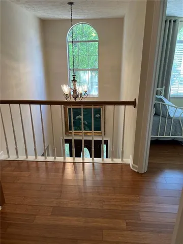 a bedroom with a bed wooden floor and flat screen tv