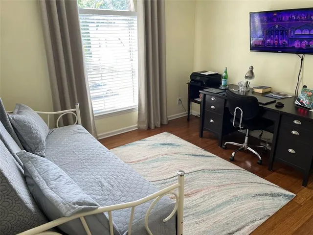 a bedroom with a bed and wooden floor