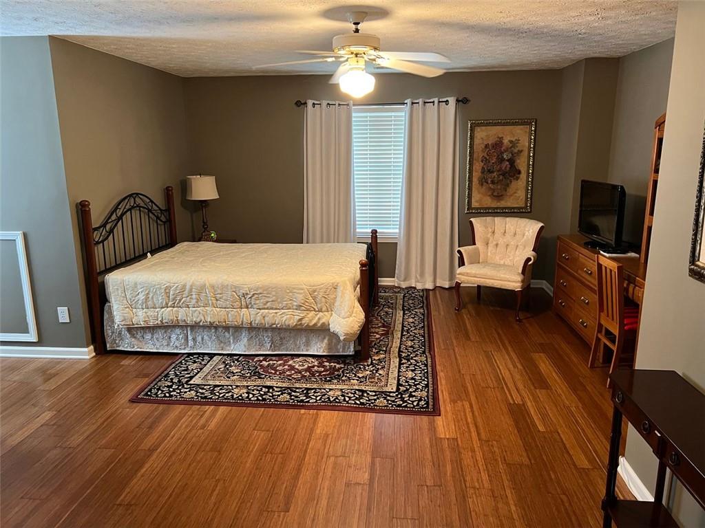 2430 Jakin Way Suwanee, GA 30024 - Photo 44 of 55 a bedroom with a bed wooden floor and flat screen tv