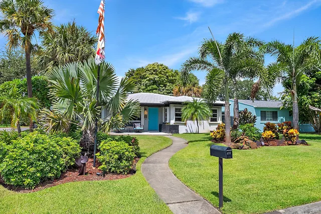a view of a house with a yard and potted plants