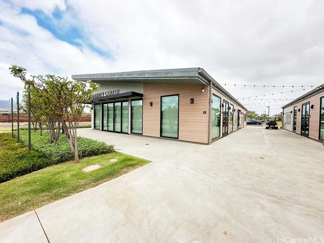a front view of a house with a yard and a large tree