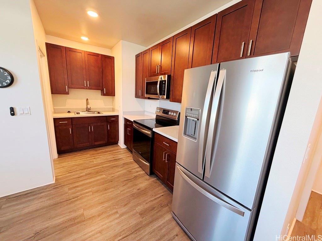 91-1560 Laauala Street Ewa Beach, HI 96706 - Photo 7 of 20 a kitchen with stainless steel appliances granite countertop a refrigerator stove and sink