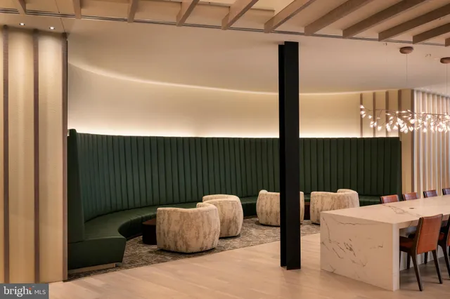 a living room with furniture and a refrigerator