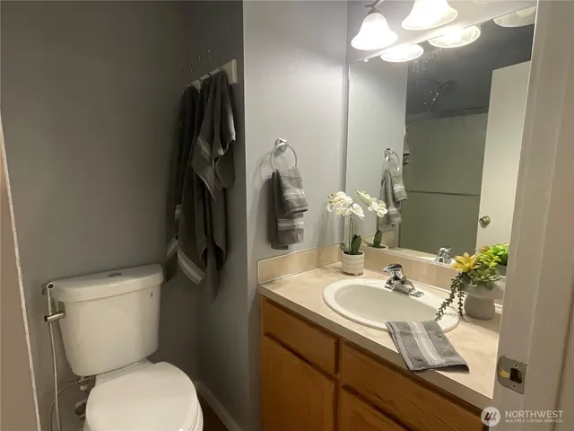 a bathroom with a sink vanity granite and toilet