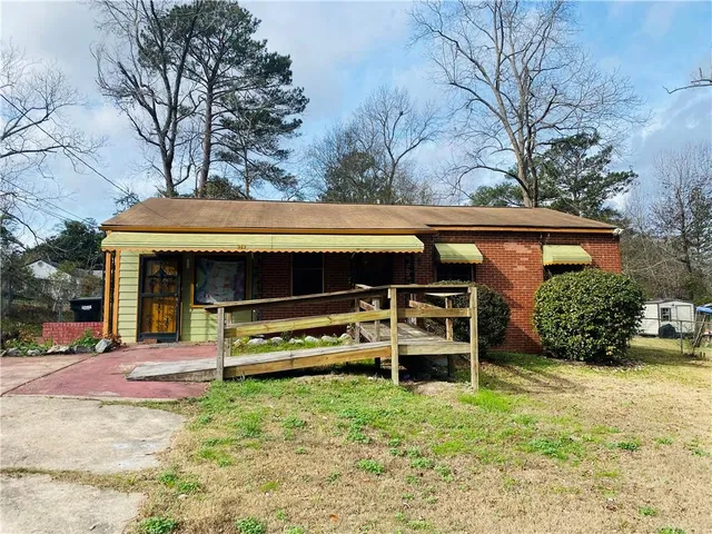 a view of a house with backyard and sitting area