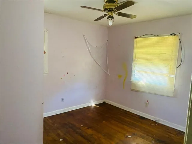 an empty room with a window and wooden floor