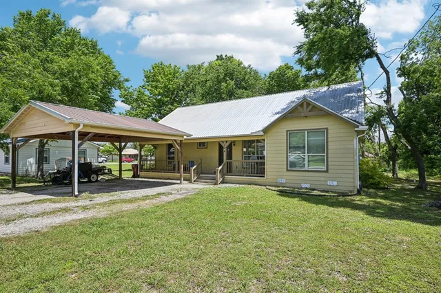 a view of a house with a yard and sitting area